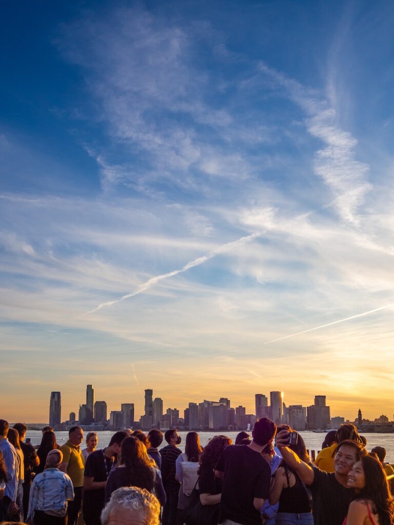 a group of tourists who traveled to new york looking at the manhattan skyline | Better Together Here